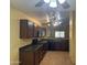 Open-concept kitchen with dark wood cabinets and modern appliances at 25798 W Miami St, Buckeye, AZ 85326