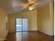 Inviting living room with vaulted ceiling, fan, and sliding glass doors with backyard views at 25798 W Miami St, Buckeye, AZ 85326