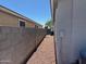 Narrow gravel-covered side yard with block wall and AC unit at 25798 W Miami St, Buckeye, AZ 85326
