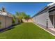 Well-maintained backyard featuring an artificial grass lawn and a block wall for privacy at 2595 E Harrison Ct, Gilbert, AZ 85295