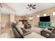 Open-concept living room with tan walls, neutral carpet, modern furnishings, and a ceiling fan at 27204 N 86Th Dr, Peoria, AZ 85383