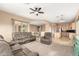 Spacious living room featuring plush grey seating, neutral walls, carpet, and an adjacent dining area at 27204 N 86Th Dr, Peoria, AZ 85383