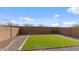 A manicured backyard featuring a well-maintained synthetic grass lawn and stone landscaping at 2855 E Tina Dr, Phoenix, AZ 85050