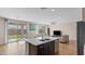 Open kitchen featuring a central island with sink, modern appliances, and sliding glass doors at 2855 E Tina Dr, Phoenix, AZ 85050