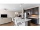Open kitchen flows into living room, stainless steel appliances and island with barstool seating at 2855 E Tina Dr, Phoenix, AZ 85050