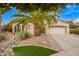 Charming home featuring a well-manicured front yard with a beautiful palm tree and lush landscaping at 2878 E Tonto Dr, Gilbert, AZ 85298