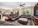 Spacious living room with comfortable seating, a ceiling fan, and large windows offering natural light at 2878 E Tonto Dr, Gilbert, AZ 85298
