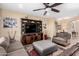 Comfortable living room with plush seating, ceiling fan, and a large entertainment center at 2878 E Tonto Dr, Gilbert, AZ 85298