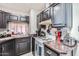 Cozy kitchen with dark cabinets, marble counters, and a view to the living room at 3002 N 32Nd St # 13, Phoenix, AZ 85018