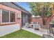 Charming outdoor patio with stylish furniture, an orange tree, and a brick accent wall at 3002 N 32Nd St # 13, Phoenix, AZ 85018