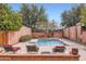 Serene pool area featuring a spa, red lounge chairs, lush greenery, and brick surround at 3002 N 32Nd St # 13, Phoenix, AZ 85018