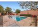 Refreshing swimming pool with a stone patio, red lounge chairs, and mature trees at 3002 N 32Nd St # 13, Phoenix, AZ 85018