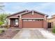 Inviting exterior view of single-story home shows a two-car garage, desert landscaping and cozy, covered entry way at 31062 N 136Th Ln, Peoria, AZ 85383