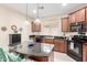 Kitchen with island, dark counters, pendant lights, and wood cabinets is stylish and efficient at 31062 N 136Th Ln, Peoria, AZ 85383