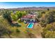 Expansive aerial view of home with refreshing pool, lush lawn, desert landscape, and serene mountain backdrop at 3264 E Vineyard Rd, Phoenix, AZ 85042