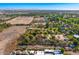 Vast aerial view of neighborhood homes, verdant desert landscape, and distant mountains under a clear sky at 3264 E Vineyard Rd, Phoenix, AZ 85042