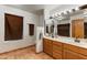 Well-lit bathroom featuring a double sink vanity and tile flooring at 3264 E Vineyard Rd, Phoenix, AZ 85042