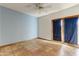 Spacious bedroom with tile flooring, blue accent wall, and sliding glass doors at 3264 E Vineyard Rd, Phoenix, AZ 85042