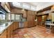 Well-equipped kitchen with granite countertops, Saltillo tile flooring, and wood cabinetry at 3264 E Vineyard Rd, Phoenix, AZ 85042