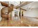 Bright living room featuring a spiral staircase, Saltillo tile flooring, and large windows for ample natural light at 3264 E Vineyard Rd, Phoenix, AZ 85042