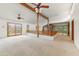 Expansive living room with exposed beams, carpet flooring, and multiple doors at 3264 E Vineyard Rd, Phoenix, AZ 85042