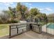 Built-in stainless steel outdoor kitchen and bar area with a built-in grill, adjacent to the backyard pool at 3264 E Vineyard Rd, Phoenix, AZ 85042