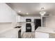 Open kitchen features sleek black appliances, white cabinets, and modern lighting fixtures at 3626 W Elm St, Phoenix, AZ 85019