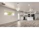 Open-concept space featuring an eat-in kitchen with modern appliances, white cabinets, and stylish pendant lighting at 3626 W Elm St, Phoenix, AZ 85019