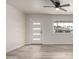 Bright, airy living room with wood-look flooring, a modern ceiling fan, and a large window at 3626 W Elm St, Phoenix, AZ 85019