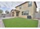 View of the backyard with artificial grass, a covered patio, and privacy walls at 40262 W Molly Ln # 138, Maricopa, AZ 85138