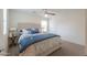 Bedroom with a luxurious, tufted headboard and stylish blue accents on the bedding at 40262 W Molly Ln # 138, Maricopa, AZ 85138