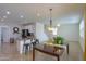 Open-concept dining area adjacent to the kitchen, offering a modern chandelier and bar stool seating at 40262 W Molly Ln # 138, Maricopa, AZ 85138