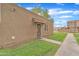 View of a tan building with a secure entry door and small porch, complemented by a green lawn at 4258 N 68Th Dr, Phoenix, AZ 85033