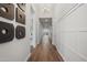 Long hallway features hardwood floors, modern light fixture, decorative wall panels, and artistic wall decor at 440 E Aurora Dr, San Tan Valley, AZ 85140