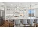 Bright kitchen with white cabinets, island with seating, stainless steel appliances, and pendant lighting at 440 E Aurora Dr, San Tan Valley, AZ 85140