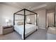 A canopy bed with neutral linens, side tables with lamps, and an ensuite bathroom for convenience at 440 E Aurora Dr, San Tan Valley, AZ 85140
