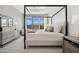 A bright room featuring a canopy bed and large window, next to a modern style dresser and side table at 440 E Aurora Dr, San Tan Valley, AZ 85140