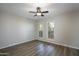 A bright bedroom featuring wood-look floors, a ceiling fan and a pair of shuttered windows at 4605 E Valley View Dr, Phoenix, AZ 85044