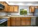 Updated kitchen with granite counters, wood cabinets, and stainless steel appliances at 4605 E Valley View Dr, Phoenix, AZ 85044