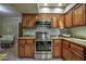 Modern kitchen with stainless steel appliances, granite countertops, and wood cabinets at 4605 E Valley View Dr, Phoenix, AZ 85044
