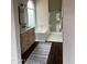 Bright bathroom featuring a soaking tub, sleek vanity with dark fixtures, and glass-enclosed shower at 4751 E White Aster St, Phoenix, AZ 85044