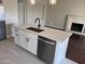 Kitchen island with stainless steel appliances, white cabinetry, and quartz countertop at 4751 E White Aster St, Phoenix, AZ 85044