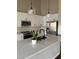 Modern kitchen features white cabinets, quartz countertops, stainless steel appliances, and stylish pendant lighting at 4751 E White Aster St, Phoenix, AZ 85044