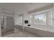 Bright bathroom features a soaking tub, a large window, and a walk-in closet at 5332 W Linda Ln, Chandler, AZ 85226