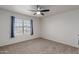 Bright bedroom featuring a ceiling fan, neutral carpet and a window at 5332 W Linda Ln, Chandler, AZ 85226