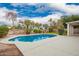 Inviting backyard pool surrounded by mature landscaping and blue skies, creating a serene oasis at 5332 W Linda Ln, Chandler, AZ 85226