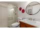 Modern bathroom featuring a glass-enclosed shower, wood vanity, and decorative round mirror at 5518 E Lindstrom Ln # 2038, Mesa, AZ 85215