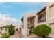 Exterior view of a community building featuring a well manicured landscape, staircase and balconies with wrought iron at 5518 E Lindstrom Ln # 2038, Mesa, AZ 85215