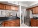 Kitchen is equipped with stainless steel appliances, wood cabinets, and a breakfast bar overlooking the living room at 5518 E Lindstrom Ln # 2038, Mesa, AZ 85215