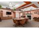 A spacious room featuring a fireplace, wooden beams, large table and mounted television for meetings or events at 5518 E Lindstrom Ln # 2038, Mesa, AZ 85215